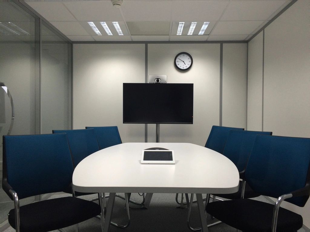 A meeting room with a long table and chairs